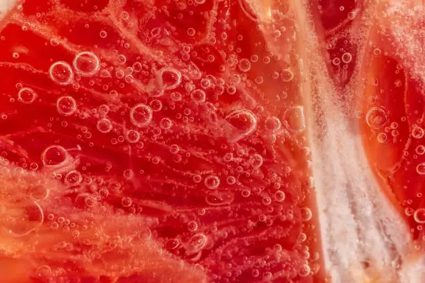 Grapefruit close up macro, under water, for juice. Ripe juicy fruit in water
