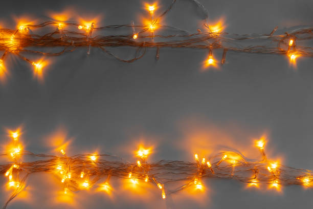 istock Glowing golden electric garland on a gray background 1336458929