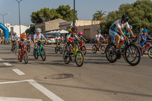 Campos, Spain; august 14 2021: Children's cycling competition at sunset as part of the festivities of the patron saint of the Majorcan town of Campos. Measures to de-escalate the Coronavirus pandemic