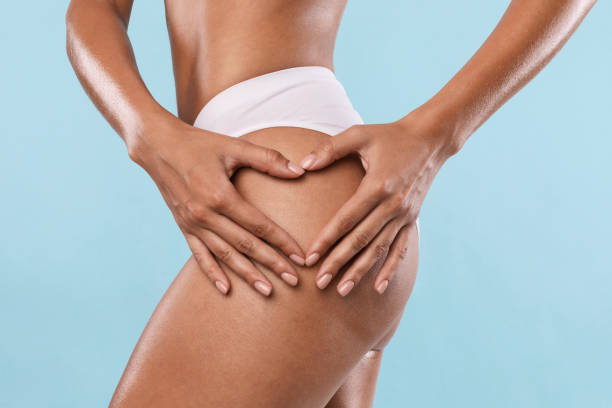 self love. woman making heart sign gesture on buttocks - oppakken stockfoto's en -beelden