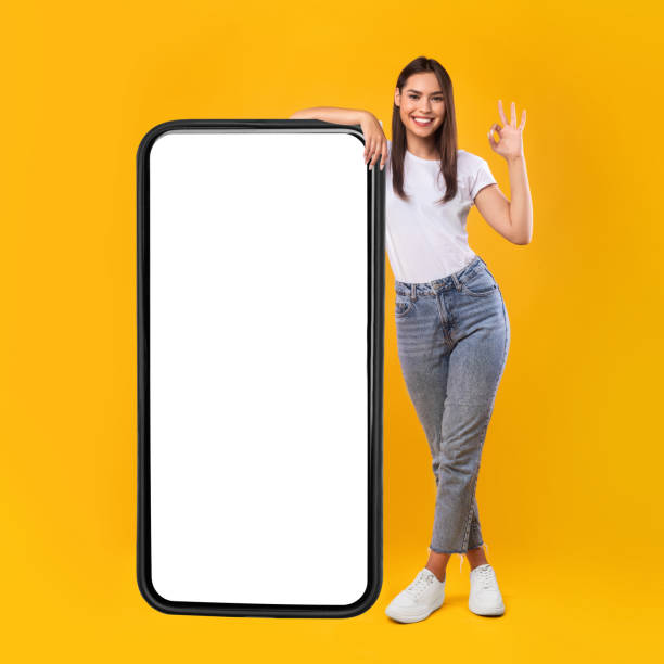 istock Woman showing white empty smartphone screen and ok sign 1336464607