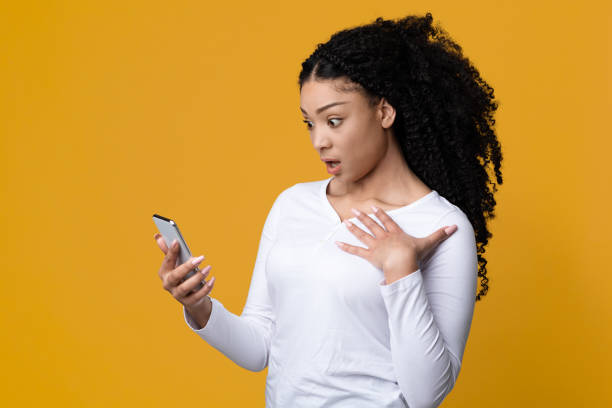 istock Shock Content. Dazed African American Woman Looking At Smartphone Screen 1336464718