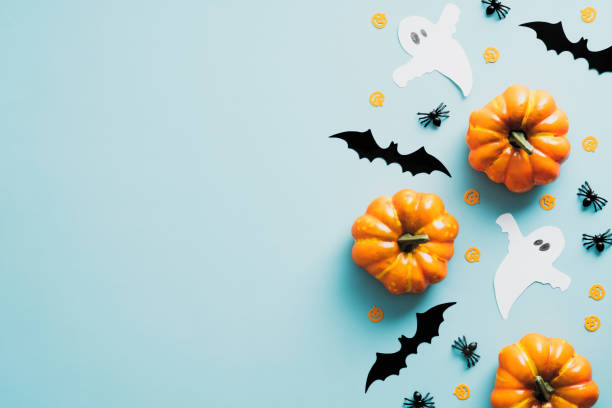 istock Happy Halloween party invitation card with decorations, pumpkins, ghosts, bats on blue background, Vintage style. Flat lay, top view, copy space. 1336464729