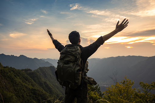 Tourist on top of mountain with arms raised