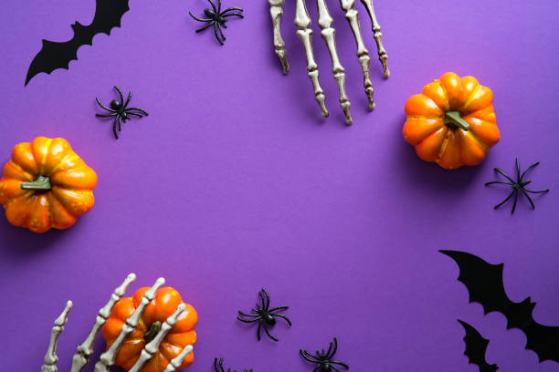 istock Halloween decorations, pumpkins, spiders, bats on violet background. Flat lay, top view, copy space. Halloween greeting card mockup. 1336464847