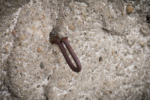 istock Rusty bent nail in a concrete wall. Close up 1336465049