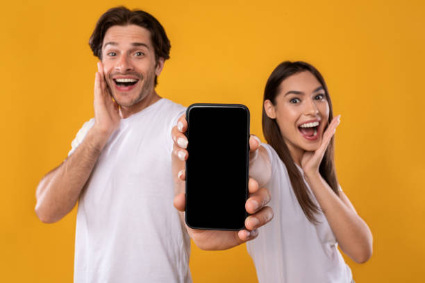 istock Couple showing blank empty smartphone screen for mockup 1336465293