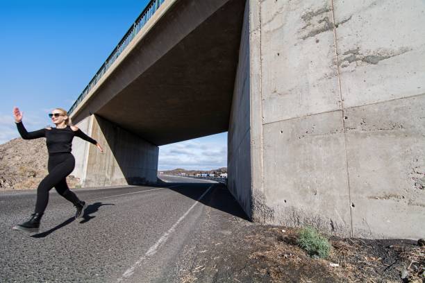 istock Woman dressed in black running off a bridge 1336466312