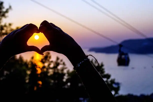Photo of Teleferic cable car and little girl showing heart shape