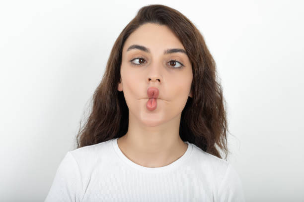 Young woman makes fish lips Young woman makes fish lips fish lips stock pictures, royalty-free photos & images