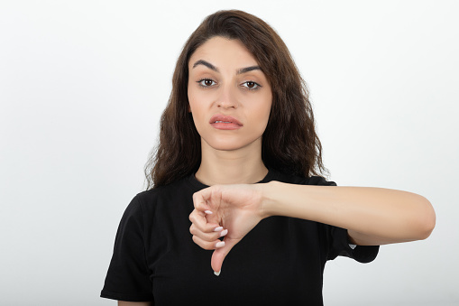 Angry woman with thumbs down looking at camera