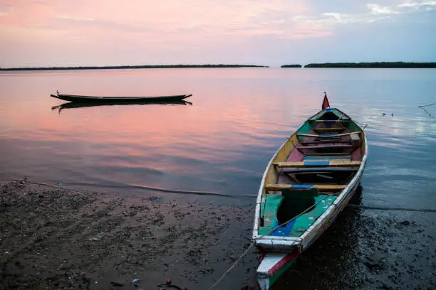 Colorful sunset. Fishing boats left on the shore in Saloum Delta, Senegal