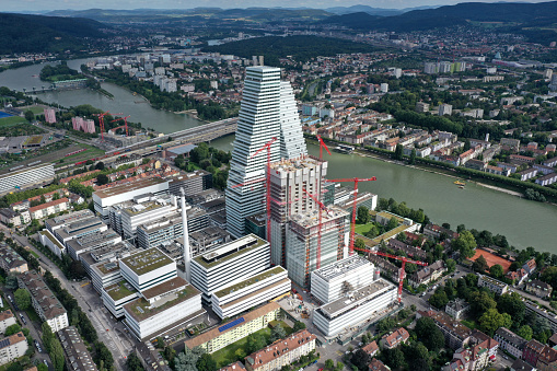 Headquarters of the  Swiss multinational healthcare company Roche. Roche Holding was founded in 1896. The Company has arround 94,000 employees (2017). The image shows the Roche headqurters with the Tower 1(178m) and Tower 2(205m) and several other buildings under construction