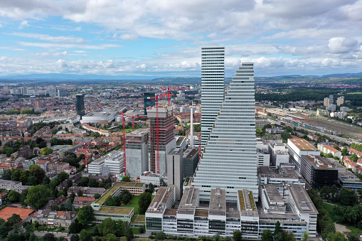 Headquarters of the  Swiss multinational healthcare company Roche. Roche Holding was founded in 1896. The Company has arround 94,000 employees (2017). The image shows the Roche headqurters with the Tower 1(178m) and Tower 2(205m) and several other buildings under construction