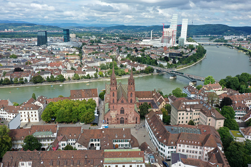 Basel City panoramic wiev over the old town with Basel Minster and several modern skysvcrapers in the background. The high angle image was captured during summer season.