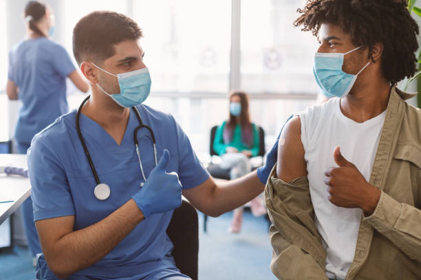 istock Vaccinated Black Guy And Doctor Gesturing Thumbs-Up At Clinic 1336474487