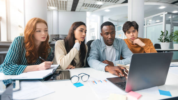 istock Group of focused international people using laptop at classroom 1336474807