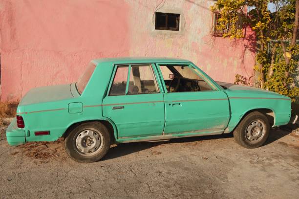 istock aged old vintage green car in pink wall 1336479954