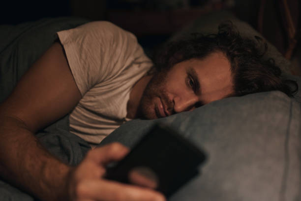 istock Cropped shot of a handsome young man using his cellphone while lying in bed at home 1336480636
