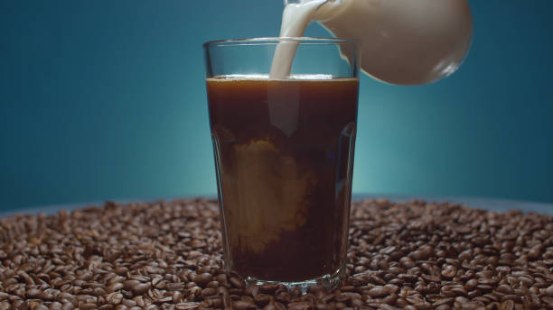 istock Milk pouring into a glass with coffee 1336480915