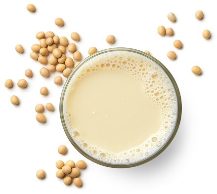 Glass of fresh vegan soy milk isolated on white background, top view. Dairy free, plant based drink.