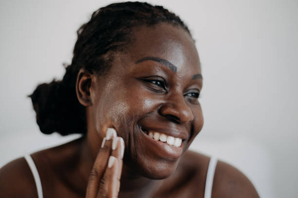 skin care using cosmetic skin cream woman with black skin - äldre kvinna hudvård bildbanksfoton och bilder
