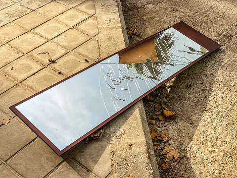 High angle view of broken mirror left in the street reflecting the sky