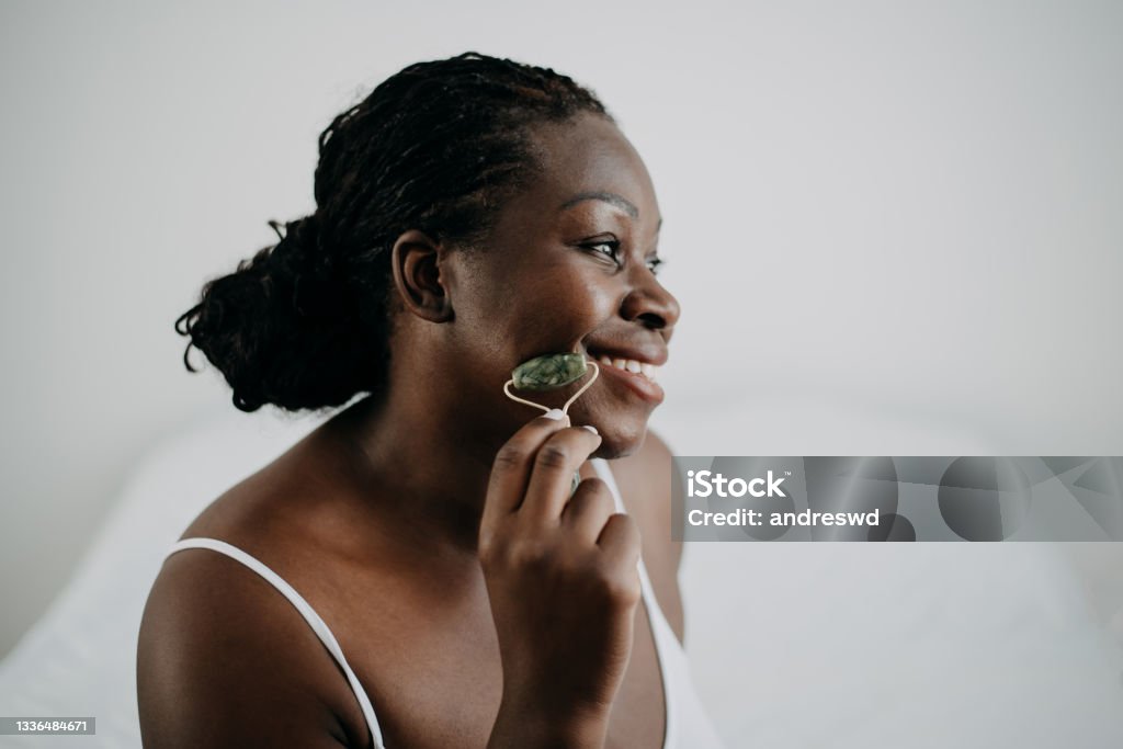 skin care black woman Using Jade Facial Rollers skin care black woman Jade Roller Stock Photo