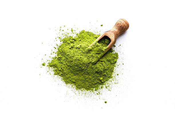 Heap of Matcha tea powder shot from above on white Overhead view of Matcha tea powder heap isolated on white background. A wooden serving scoop complete the composition. High resolution 42Mp studio digital capture taken with Sony A7rII and Sony FE 90mm f2.8 macro G OSS lens chlorella stock pictures, royalty-free photos & images