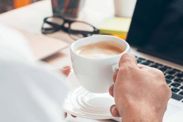 istock Young businessman working at laptop computer with hot coffee in hand. 1336486704