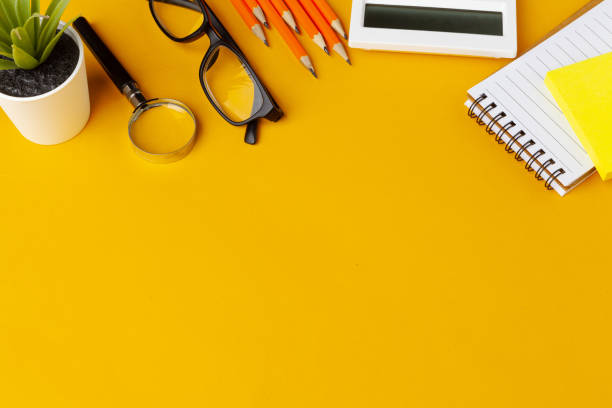 istock Stylish messy yellow desk top with various stationery top view 1336487374