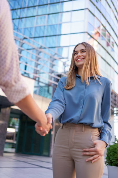 istock Woman hands shake on business building background 1336488065