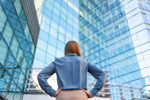 istock Back view woman looking business building 1336488070