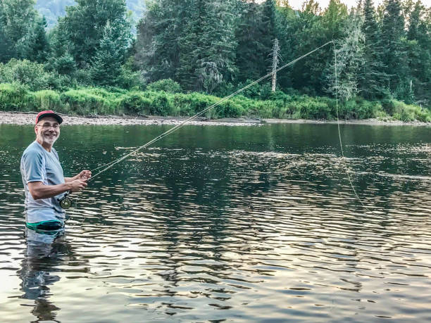 istock Man fly fishing in river 1336489880