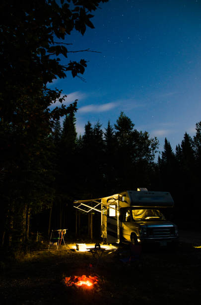 istock Motorhome parked in forest at night 1336490791