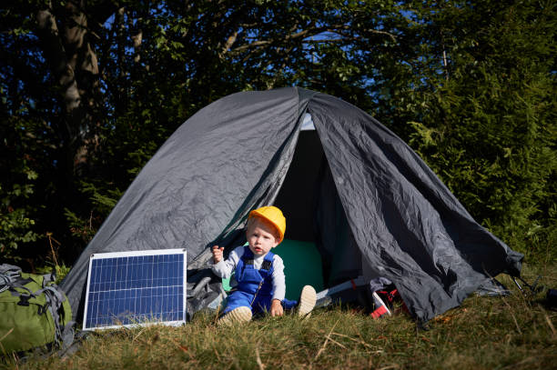 istock Little boy resting in tent near solar panel. 1336491105
