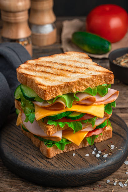 istock A large sandwich with ham, cheese, tomatoes and cucumber close-up. Side view 1336497429