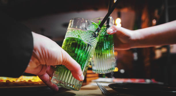 istock Two hands (male and female) clinking toasting with mojito cocktails in cafe or bar 1336501131