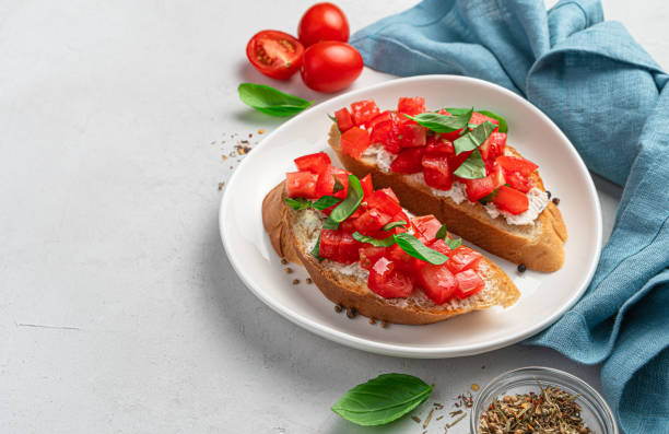 istock Bruschetta with tomatoes, feta and basil on a gray background 1336501729