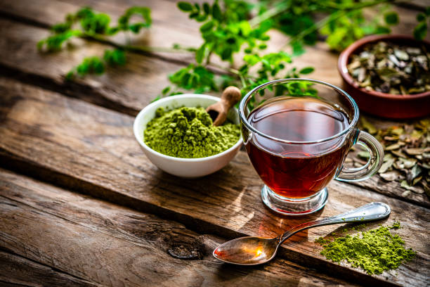Ground Moringa and Moringa tea on rustic table stock photo