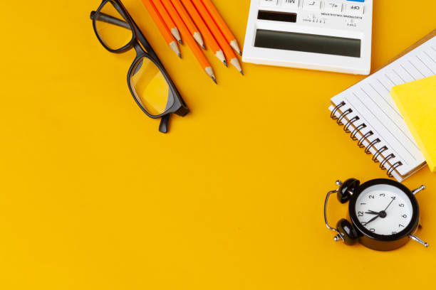 Stylish messy yellow desk top with various stationery top view