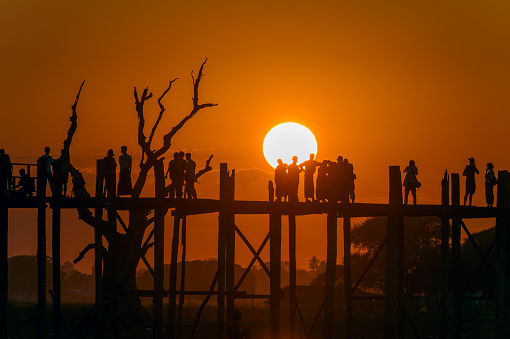 Myanmar. Amarapura, region of Mandalay. People walking on the bridge U Bein, in teak wood, 1200 meters long, crosses Lake Taugthman