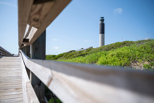 The Oak Island Lighthouse viewed through the railings of the walkway leading to the beach