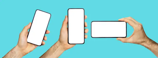 Photo of Empty screen background in hand isolated. Hand with a white screen of a mobile phone in different positions on a blue background