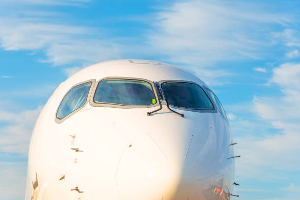 istock Passenger airplane nose cockpit in blue clouds evening sky. 1336511539