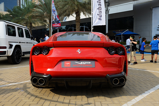 Dubai, UAE - November 16, 2019: The Ferrari 812 Superfast sportscar is near entrance of building of Dubai Motor Show 2019.