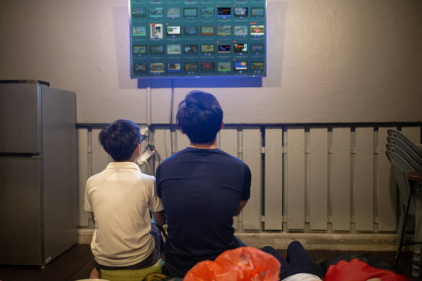 Asian Chinese father playing video games with his son