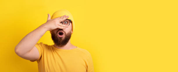 istock shocked man looking through fingers 1336515435