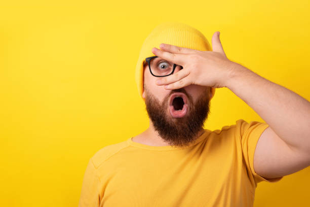 istock shocked man looking through fingers 1336515436