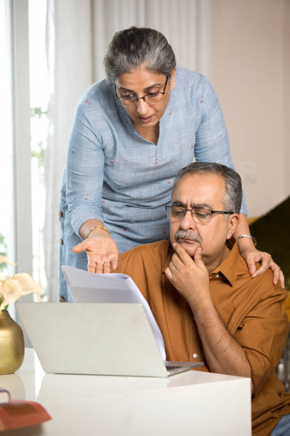 istock Worried old couple reading a document at home 1336515473